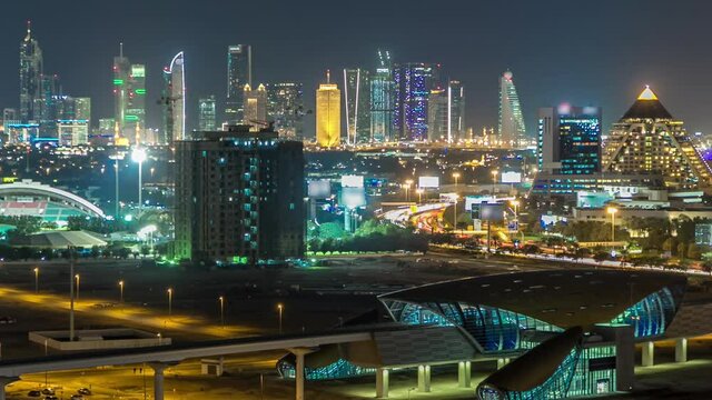Dubai downtown skyline aerial timelapse at night. Top view of Sheikh Zayed road with numerous illuminated towers, skyscrapers and metro station. Traffic on the road. Famous landmark