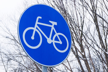 Bike road sign. Winter cycling background. Bicycle path symbol. Slippery dangerous road during snowy day. Outdoor winter bike ride on a route.