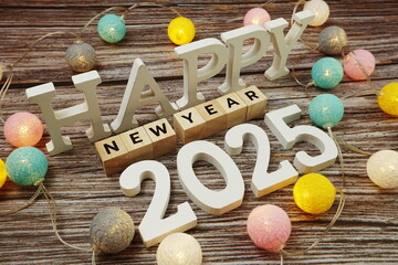 Happy New Year 2025 alphabet letter with LED cotton balls on wooden background