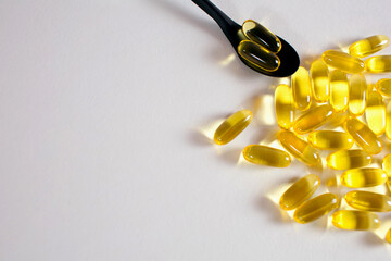 Fish oil capsules on white background with free space for text. In a spoonful of fish oil capsules....