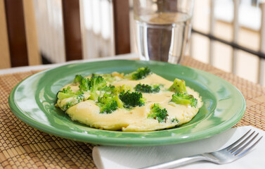 wholesome breakfast. omelet with broccoli on green plate