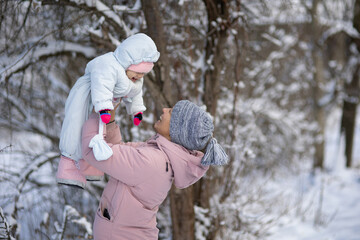 Fototapeta na wymiar A woman with a baby on a walk in winter