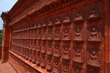 Buddha sculptures are on the whole wall in a Buddhist cultural tourist area