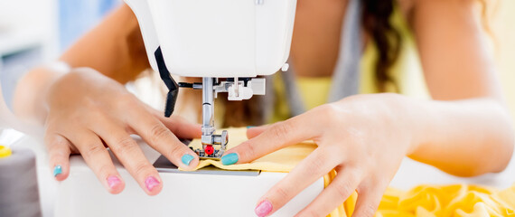 Cropped image of tailor hands working on sewing machine