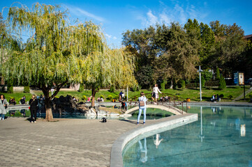 Yerevan, Armenia - October 31, 2019: Girls taking photographs by the Swan Lake in the center of Yerevan, Armenia