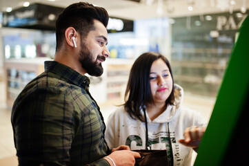 Indian couple performs transactions from the bank atm.
