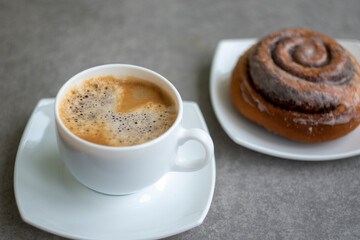 Cup of coffee with home baked cinnamon roll/ cinnabon