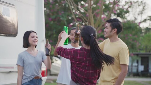 Friend clinking and drinking bottles of beer with happiness and smile.