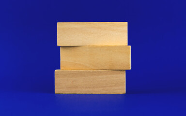 Business strategy banner or template with three wooden peg, blocks on a blue background, place for your text