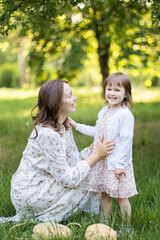 Happy young mother with daughter outdoors.