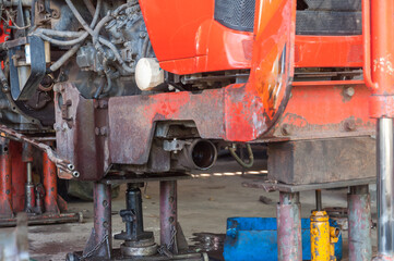 Jack is lifting the car to perform various repairs on the tractor.