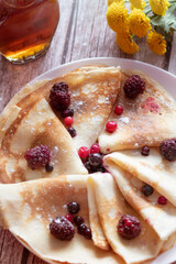 
Homemade pancakes, delicious thin pancakes with berries and maple syrup