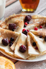 
Homemade pancakes, delicious thin pancakes with berries and maple syrup