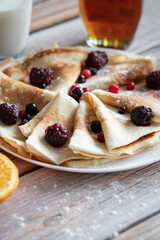 
Homemade pancakes, delicious thin pancakes with berries and maple syrup