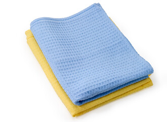 Folded blue and yellow waffle towels on a white background