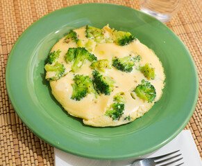 wholesome breakfast. omelet with broccoli on green plate