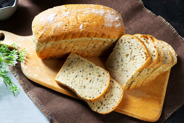 Black sesame bread freshly baked homemade is placed on a wooden cutting board and cut into equal strips. Good to eat for health.