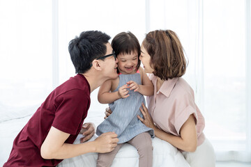 Girls with disabled disorders Learning of the brain Down syndrome constellations Laughing, merry, playing with her parents in the white bedroom bed. Happily Educational concept.