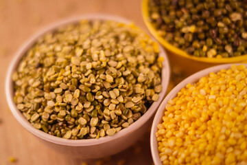 Green and yellow moong mung dal lentil pulse bean on black background, yellow Mung dal and green Moong bean rotation on wooden table, high protein moong dal