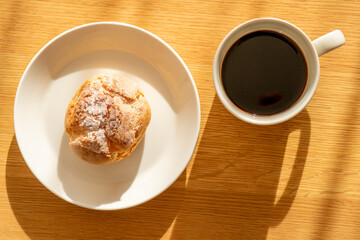 A cream puff and a cup of coffee