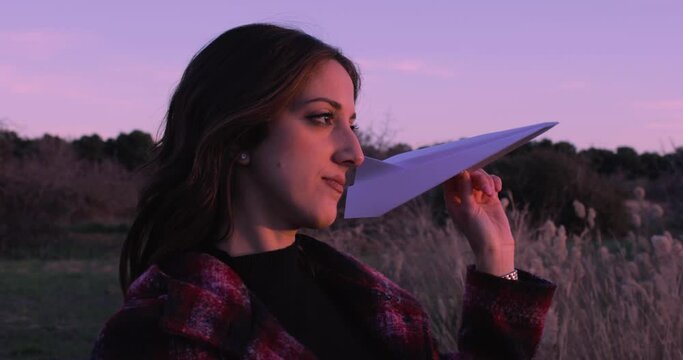 Ragazza gioca con aereo di carta nella natura