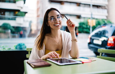 Portrait of cheerful female copywriter in classic spectacles for provide eyes protection holding...
