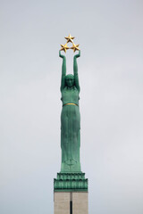 View of  9 meters Copper woman figure of Liberty with three gilded stars at the top of the Freedom Monument in Riga, symbolizing the districts of Latvia: Vidzeme, Latgale and Courland