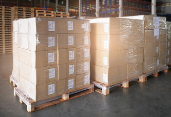 Stacked of cardboard boxes wrapped plastic film on pallet rack. Cargo shipment boxes. Warehouse storage. Manufacturing and warehousing.