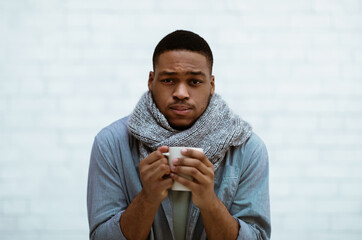 Sick Black Guy Having Chills Standing Over White Wall