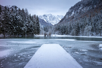 Frozen winter lake in the mountains covered with snow. Plansar lake, Jezersko Slovenia.