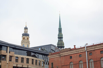 Obraz premium Famous view on latvian highest unique medieval and gothic architecture churches towers and the roofs of old houses on street in the center of capital old city Riga, Latvia, the Baltics region 