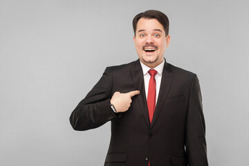 Do you raise me in office? I'll be the director of the department? indoor studio shot. isolated on gray background. handsome businessman with black suit, red tie and mustache looking at camera.