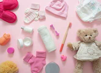 Baby bathing accesories on pink background, top view