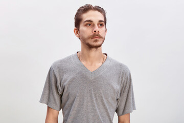 People concept - bearded face man. Friendly young man in gray shirt look in to the camera over grey background. Copy space