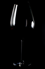 Bordeaux Wine glass with red wine on black smoke background. light reflection. 