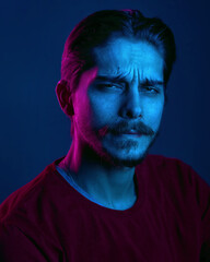 Beautiful caucasian young man portrait isolated on multicolored neon light backgroud. Human emotions, facial expression concept. Trendy colors. Advertising concept