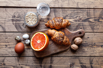 Healthy organic food: grapefruit, cereal, eggs, fresh bakery and nuts, top view