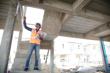 Fototapeta premium Engineer and Architect working at Construction Site with blue print. Hispanic electrician working and looking blueprint in new house construction site.