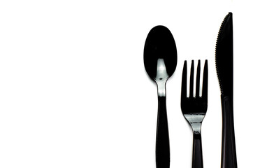 Black plastic cutlery knife fork spoon isolated on white background low highlight. For kitchen restaurant and table set up. concern to plastic conservative recycle items and one time use utensils