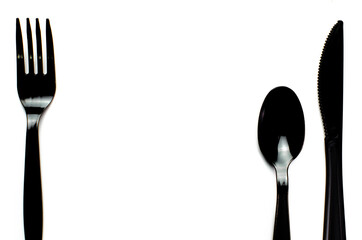 Black plastic cutlery knife fork spoon isolated on white background low highlight. For kitchen...