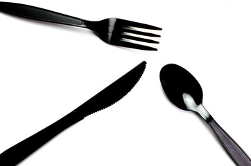 Black plastic cutlery knife fork spoon isolated on white background low highlight. For kitchen...