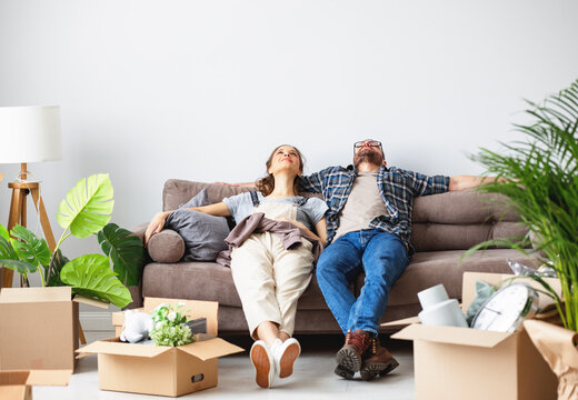 Tired Couple Relaxing On Sofa During Relocation