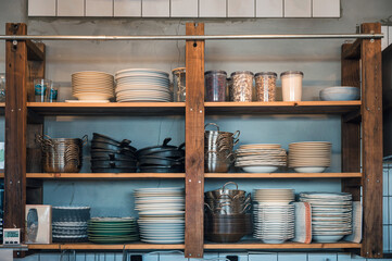 Kitchenware with dishware on kitchen wooden shelving
