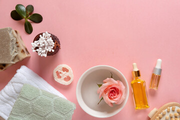 Natural skincare cosmetic products on pink pastel background. Soap, oils, sea salt. Organic cosmetics, spa concept. Empty space, flat lay, top view.