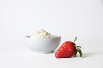 strawberry and a bowl of farmer cheese isolated against white background. Horizontal image