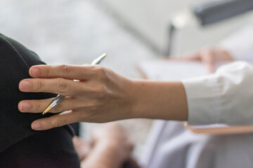 Professional medical doctor in white uniform gown coat interview counseling female patient: Physician writing on patient chart while consultation: Hospital/ clinic healthcare professionalism concept