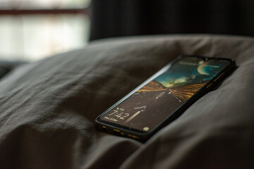 mobile phone laying on a pillow in the morning