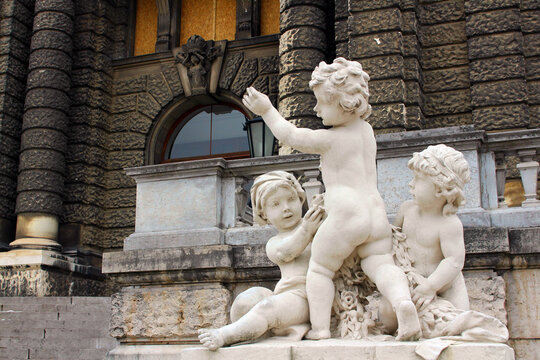 Vienna. Austria. 29 February 2020. Neue Burg Art Historical Museum Steps Decorated By Kids Sculptures In Vienna At Coudy Summer Day. Stone Figures Of Three Young Children Playing.