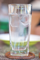 Glass of cold water with ice at restaurant