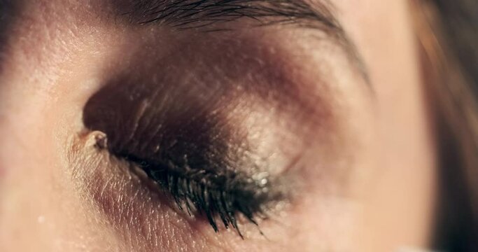 Woman cleans her eye. Young woman cleans her eye from make up, extreme close up shot of the mascara cleaning process